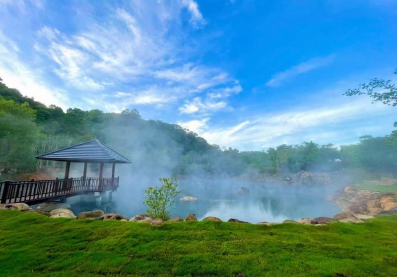 Một khung cảnh yên bình với ngôi nhà hài hòa với thiên nhiên, dòng nước trong lành, cây cối xanh tươi, thể hiện mối liên hệ giữa môi trường sống trong lành và vận mệnh con người theo quan niệm phong thủy.